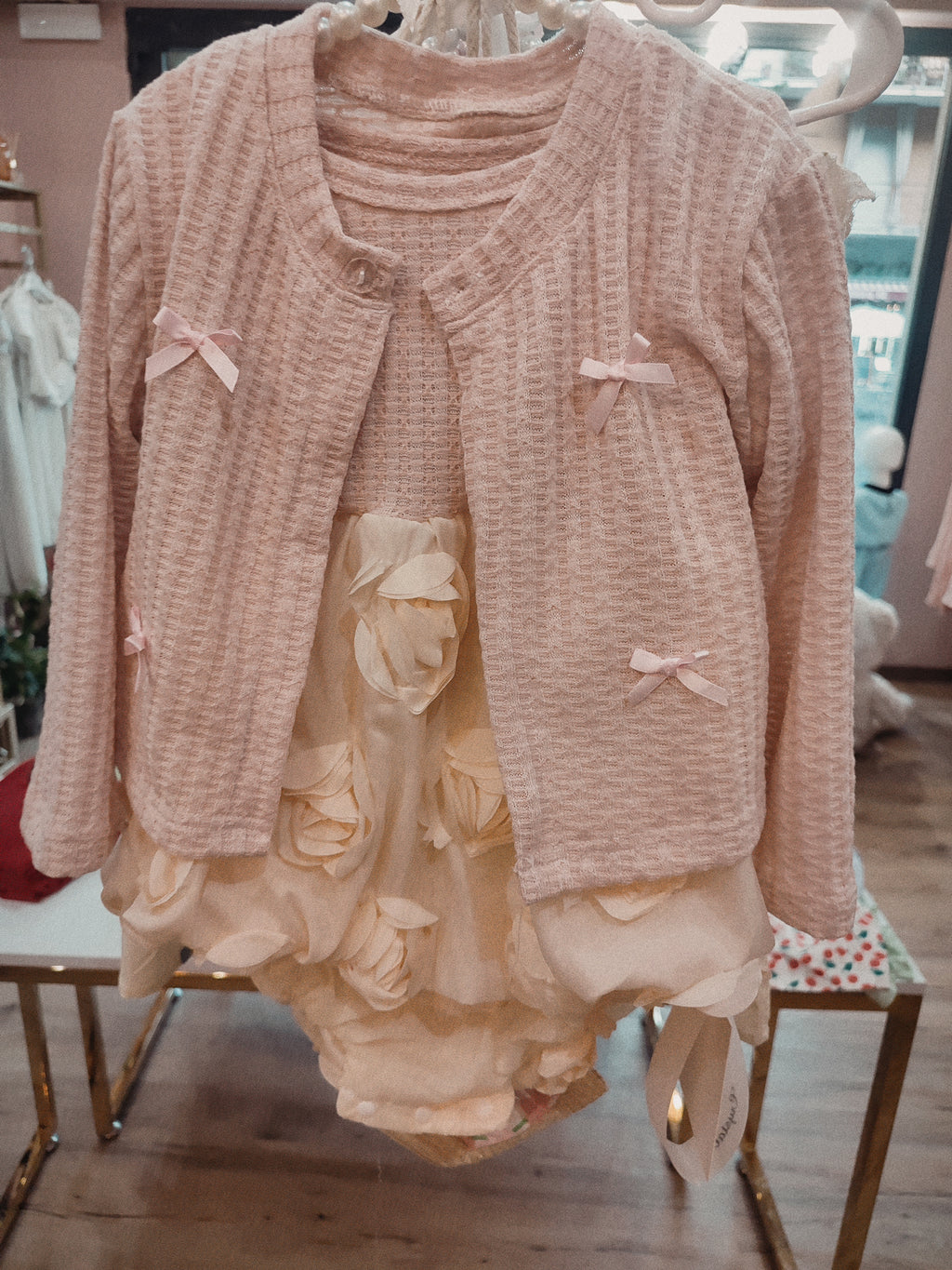 Set due pezzi composto da cardigan rosa con orecchie da coniglietto e fiocchi decorativi, abbinato a un abito 100% cotone