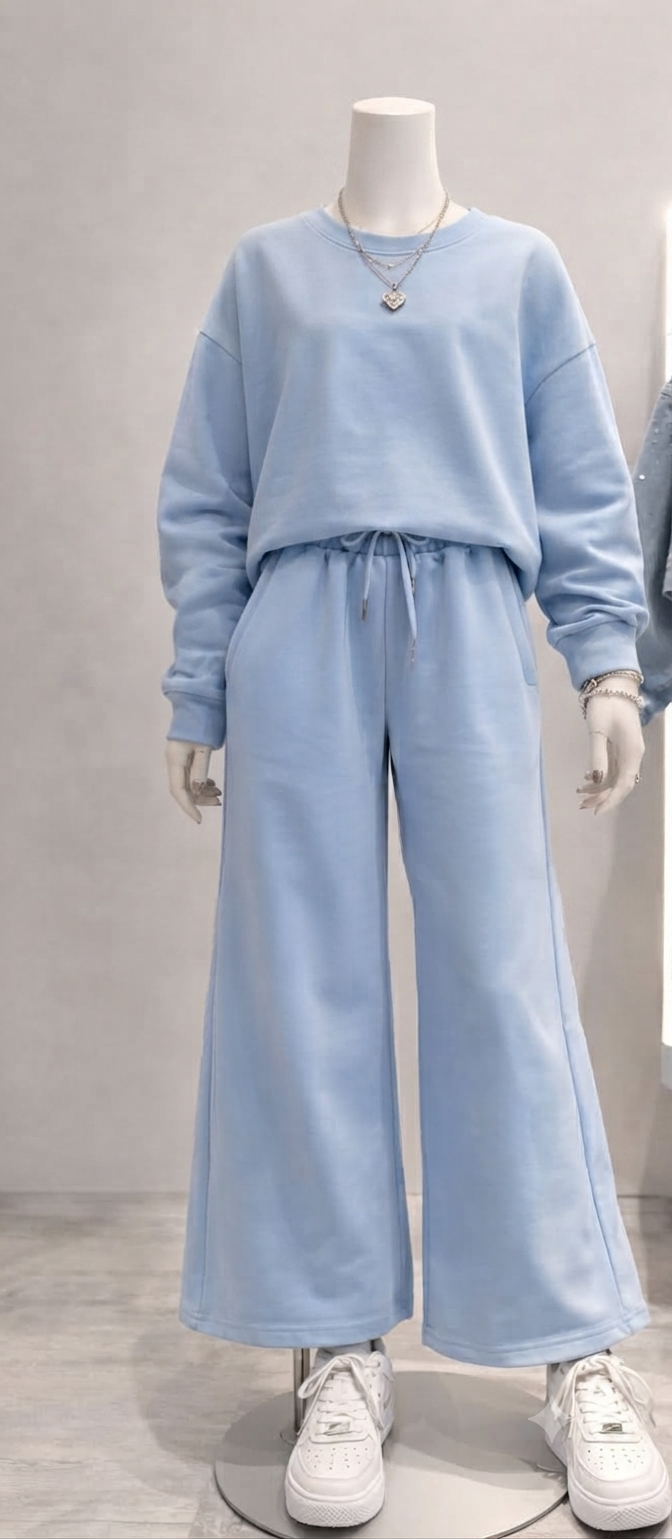 completo è composto da una felpa girocollo con una linea moderna e leggermente over, abbinata a un pantalone dalla vestibilità ampia