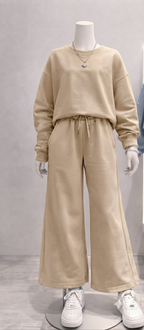 completo è composto da una felpa girocollo con una linea moderna e leggermente over, abbinata a un pantalone dalla vestibilità ampia