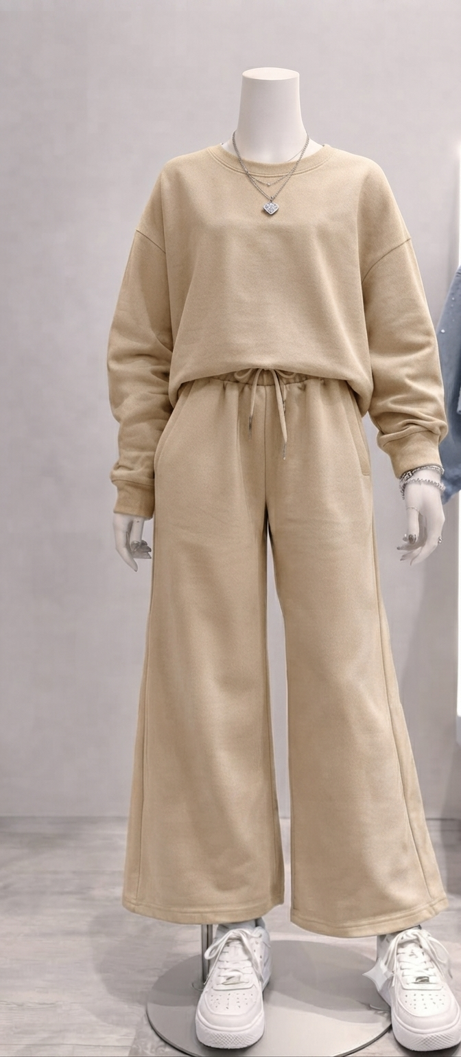 completo è composto da una felpa girocollo con una linea moderna e leggermente over, abbinata a un pantalone dalla vestibilità ampia